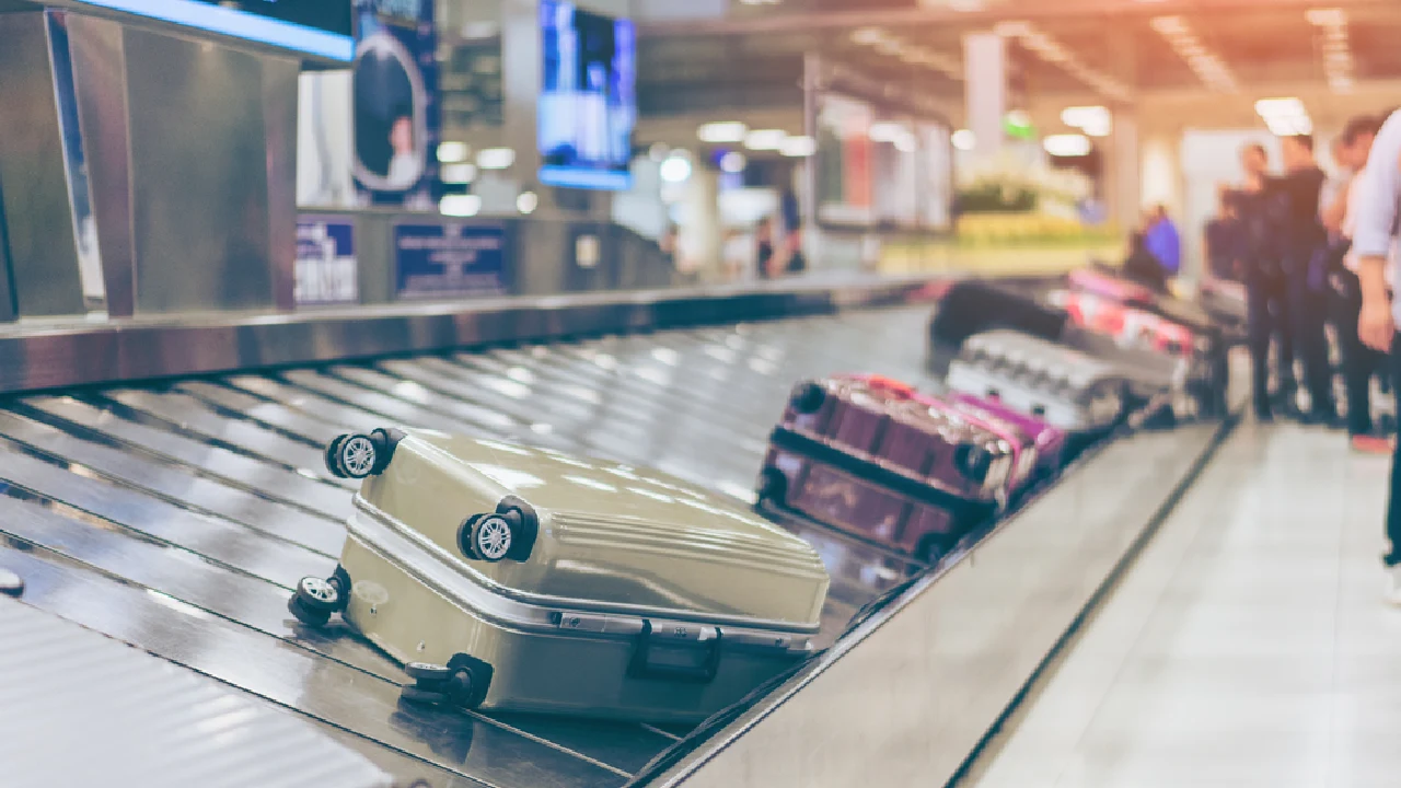 Traveler claims luggage at LAX airport Lost and Found office counter.
